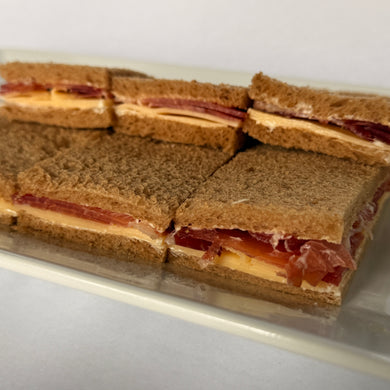 24 Sándwiches de pan negro bondiola y queso dambo de copetín